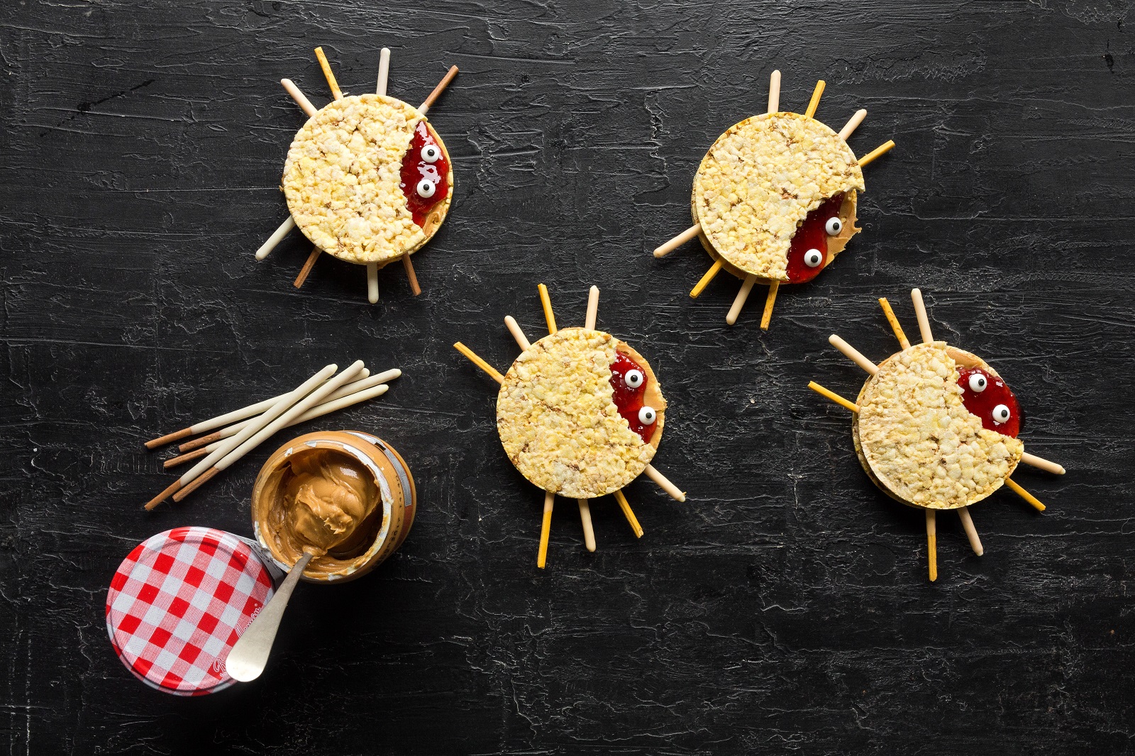 Peanut butter (or nut butter) and jam CORN THINS slices in the shape of spiders