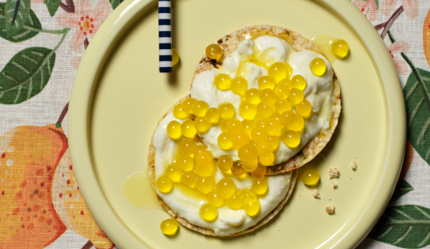 Coconut yoghurt and passionfruit pearls on Corn Thins slices